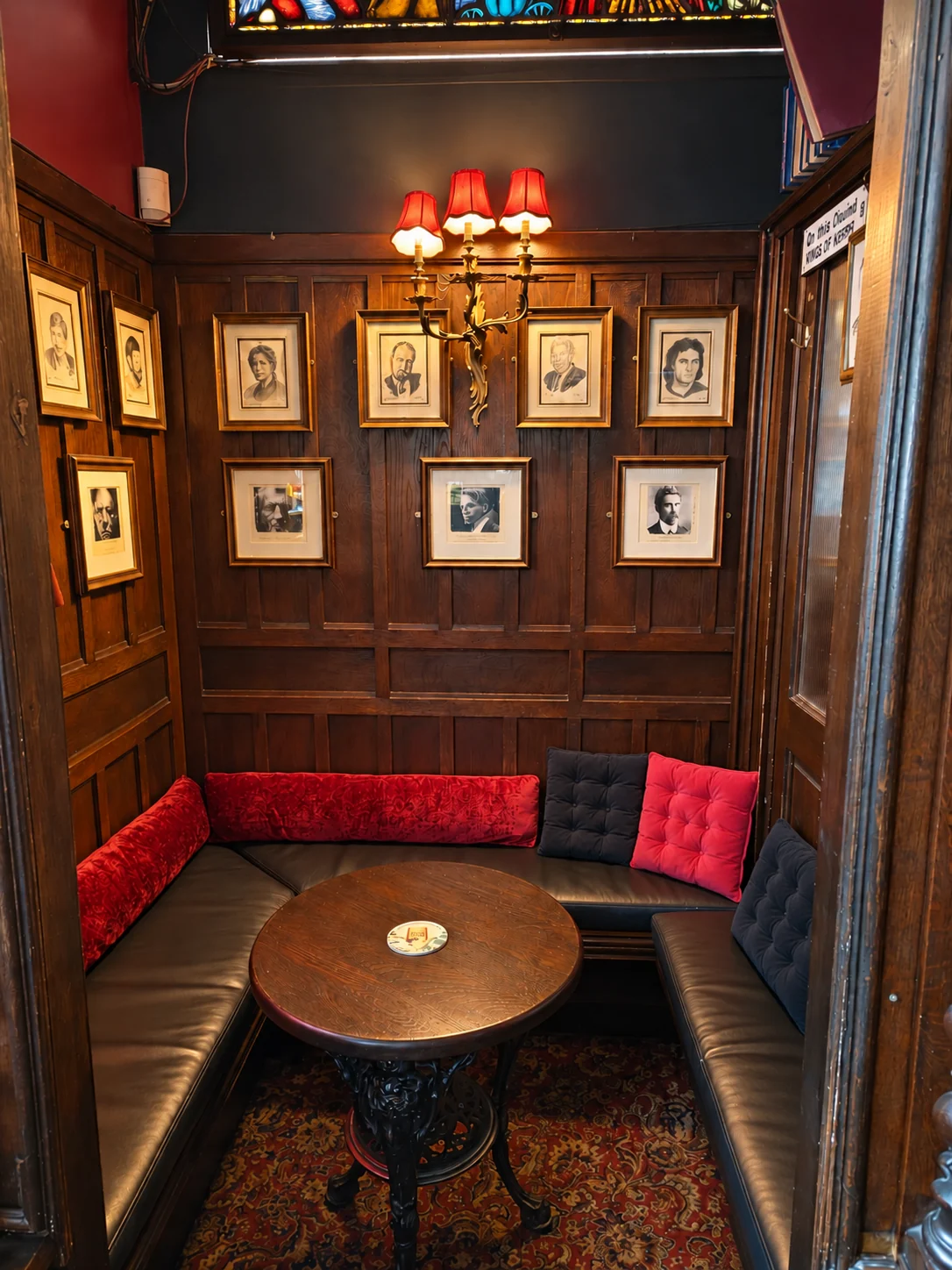 The cosy snug beside the main bar at The Flowing Tide, with timber panelling and framed portraits